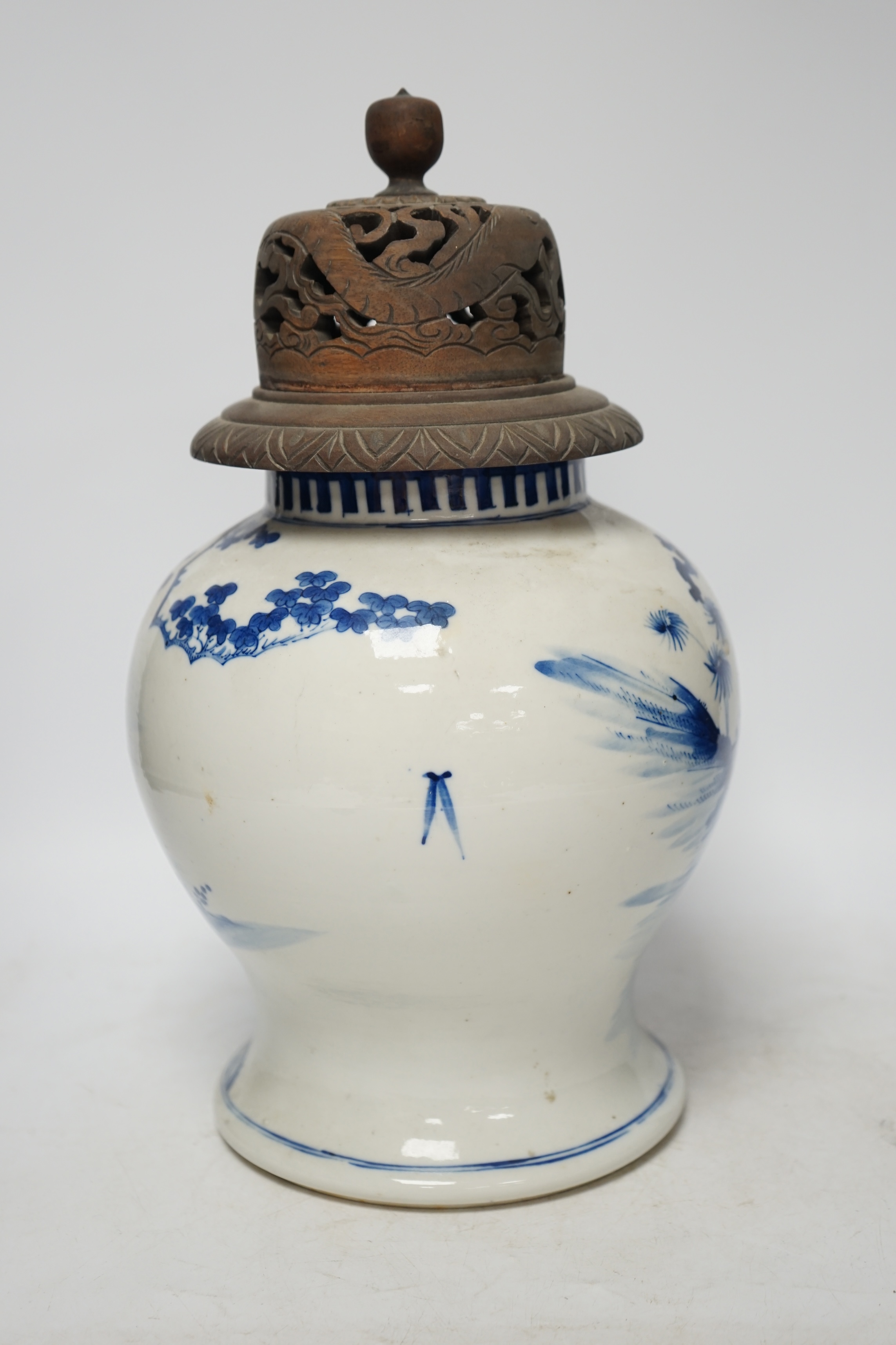 A 19th century Chinese blue and white baluster jar, painted with a dignitary and attendants at a table with objects in a garden setting, wood cover, 35cm. Condition - good